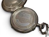 a silver pocket watch with a chain around it