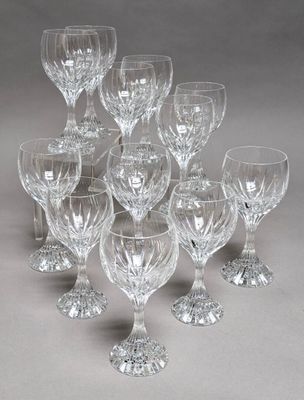 twelve crystal wine glasses on a grey background