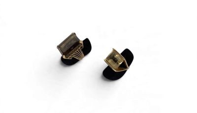 pair of black and gold stud earrings on white background