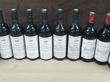 several bottles of wine are lined up in a row on a table