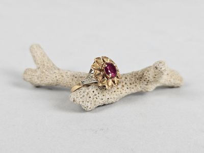 a close up of a gold ring with a ruby stone on it