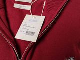 a close up of a red sweater with a tag on it