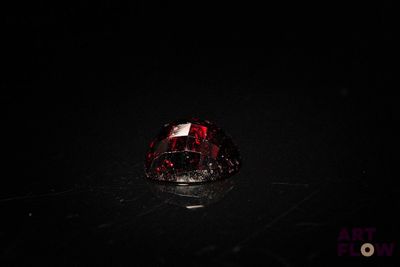 a close up of a red diamond on a black surface