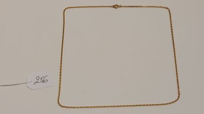 gros plan sur un collier en or portant une étiquette