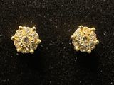 a pair of diamond stud earrings on a black surface
