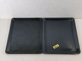 two black trays sitting on top of each other on a table