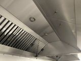 a kitchen with a stove, oven, and exhaust hood