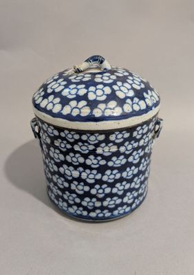 un récipient bleu et blanc orné d'un motif floral