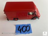 un camion jouet rouge qui se trouve à côté d'une feuille de papier bleue