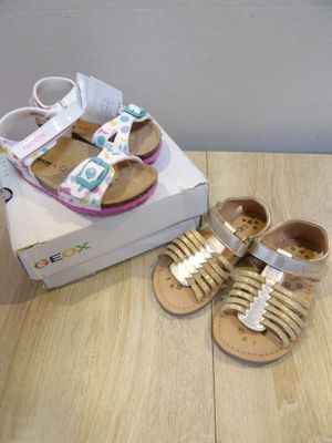 a pair of baby shoes on a table next to a shoe box