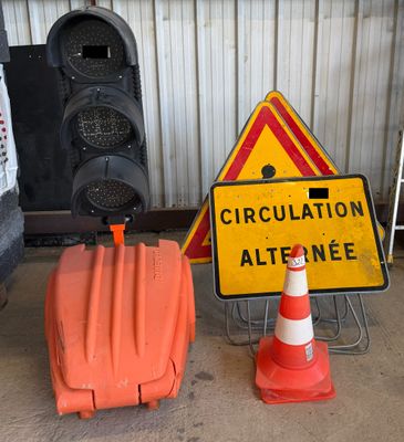 a traffic sign and a traffic cone sitting next to each other