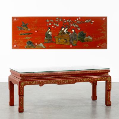 une table rouge avec un plateau en verre et un tableau accroché au mur