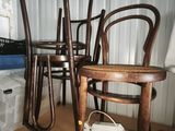 three wooden chairs sitting on a shelf in a room