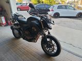 a black motorcycle parked in a garage next to a white car