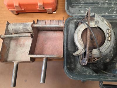 une vieille boîte à outils contenant un marteau et d'autres outils, posée sur une table