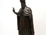 bronze statue of a man with a hat and robe holding a cane