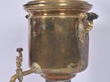 an antique brass coffee urn on a stand with a faucet