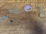 une table en bois sur laquelle se trouvent une paire de ciseaux et un collier
