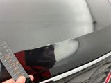 a person holding a ruler in front of a car