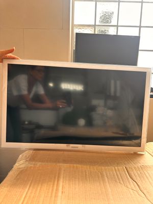a man standing next to a bed with a television on it