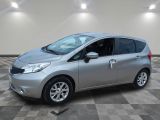 une Nissan Versa argentée garée sur un sol en dalles à damier
