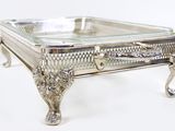 a silver tray with a glass top on a stand