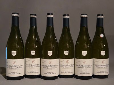 six bouteilles de vin sont alignées sur une table