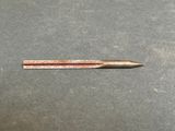a small metal pen sitting on top of a table next to a ruler