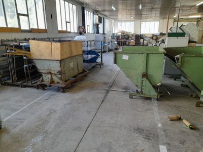 a man standing in a factory with a machine in the background