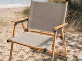 une chaise posée sur le sable au bord de l'eau