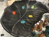 a black plate with colorful buttons on it sitting on a table