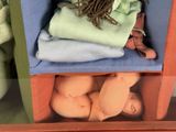 a stuffed animal sitting on a shelf next to other stuffed animals