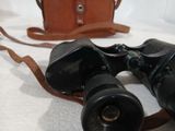 a pair of binoculars sitting on a table next to a bag