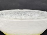 yellow and white glass bowl on black background with black background