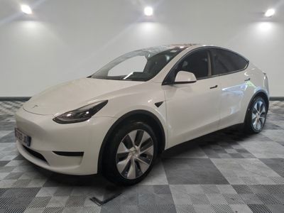the white tesla model x is parked in a clean room
