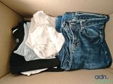 une boîte en carton remplie de vêtements et d'un jean