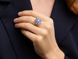 the woman is wearing a ring that has a blue stone in it