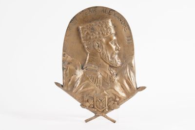 une image représentant une statue d'un homme coiffé d'un chapeau, posée sur un socle