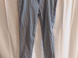 a pair of blue pants hanging on a hanger on a white curtain
