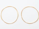 une paire de boucles d'oreilles en or sur fond blanc