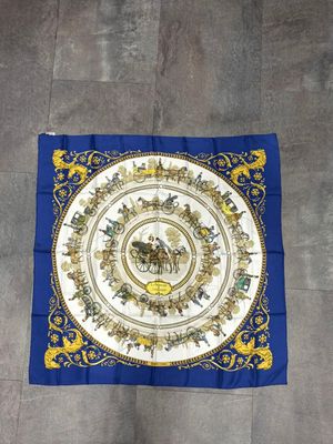 a blue and gold scarf with a picture of a horse and rider on it