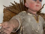 a doll of a man with a feather on his head
