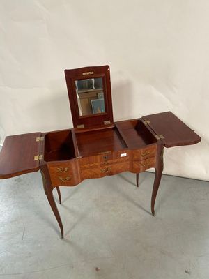 une petite table en bois sur laquelle se trouve un miroir