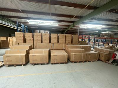 une grande quantité de cartons empilés sur des palettes dans un entrepôt