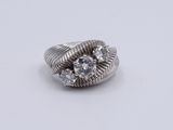 a close up of a diamond ring on a white surface