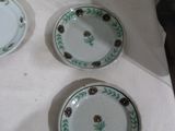 four plates with flowers are on a table with a white table cloth