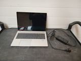 a laptop computer sitting on a table with a charger