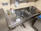 a sink in the middle of a kitchen with a lot of clutter