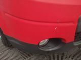 a close up of a red car with a hole in the front