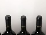 three bottles of wine are lined up on a table